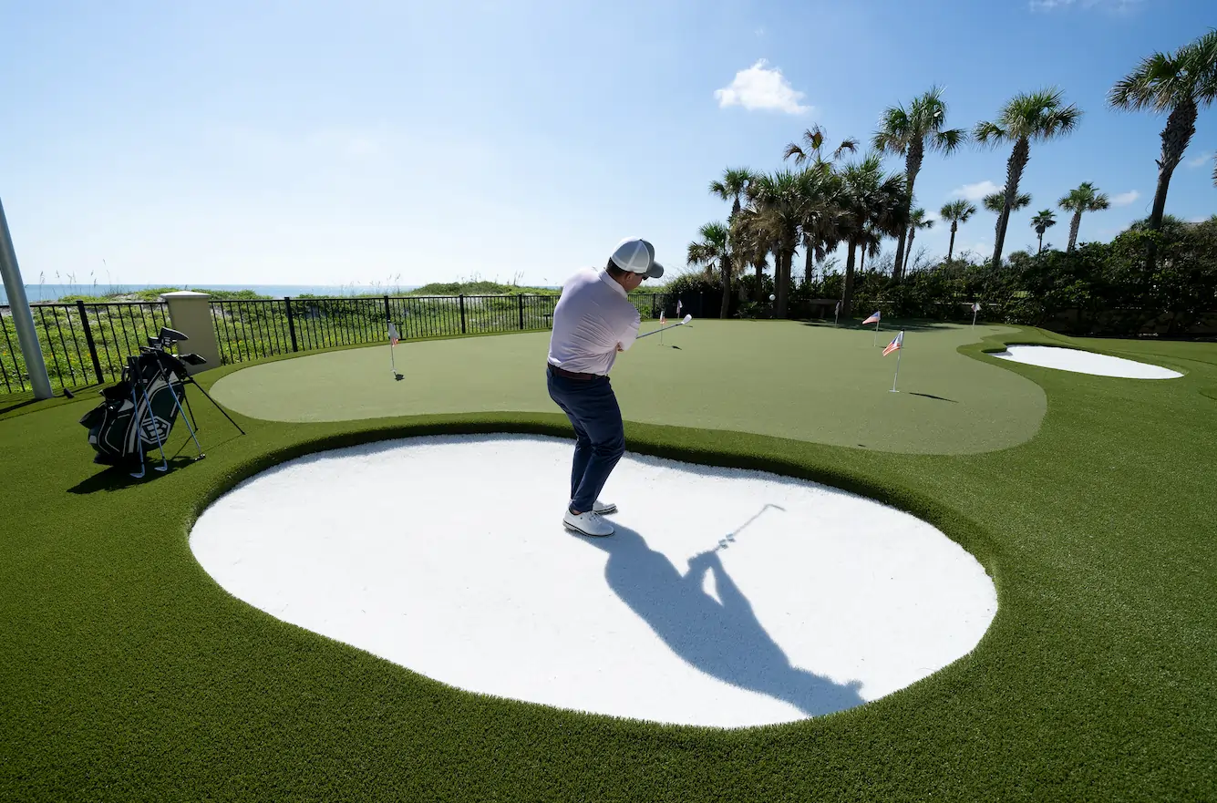 man playing golf on artificial grass lawn