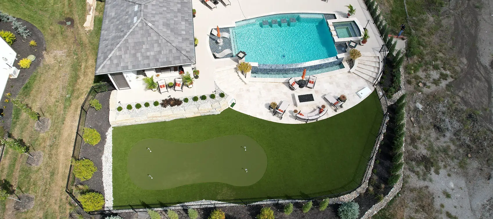 Backyard golf green pool area drone shot from SYNLawn